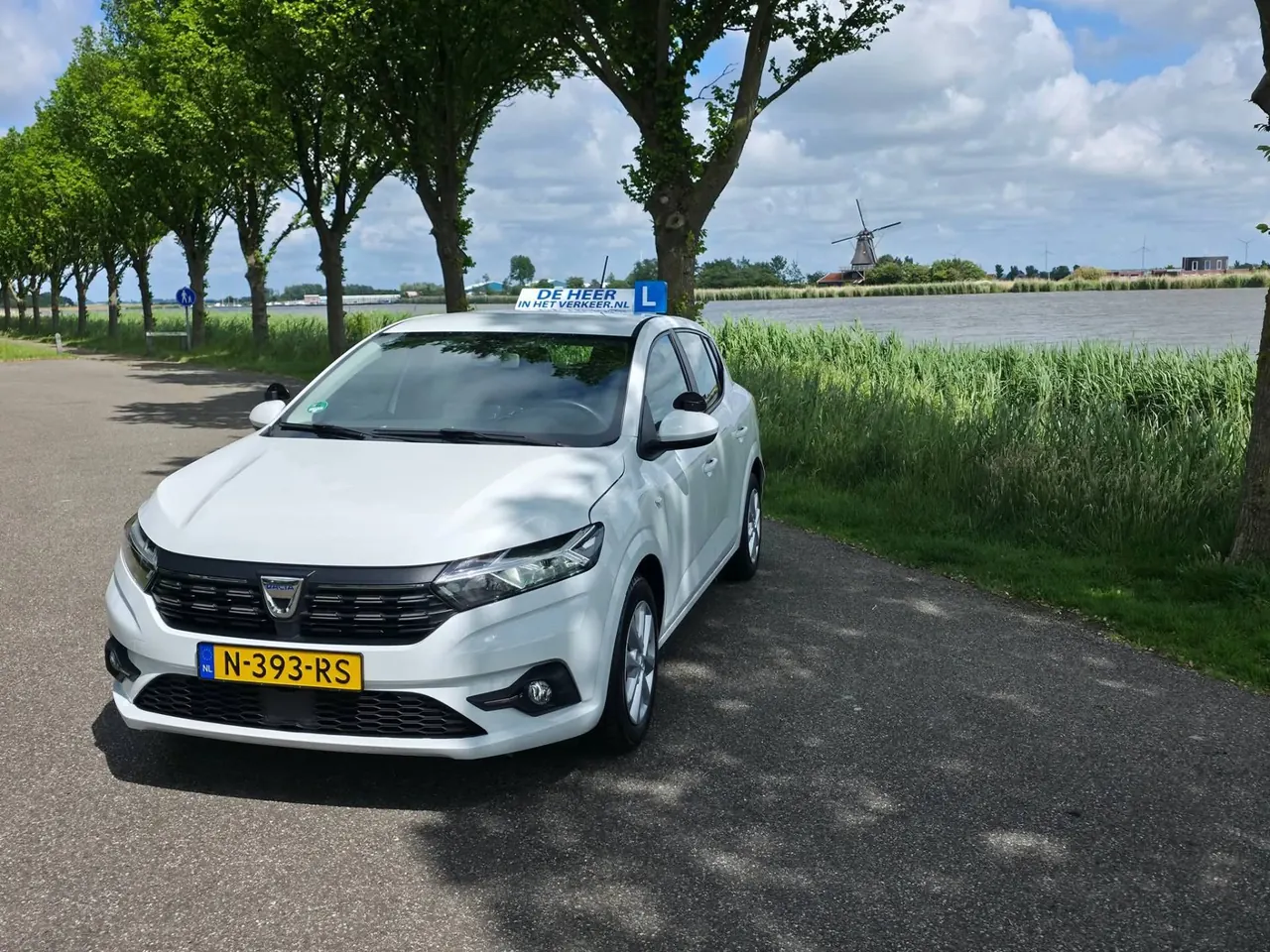 Lesauto van Autorijschool de Heer in het Verkeer langs het water in Hollands Kroon